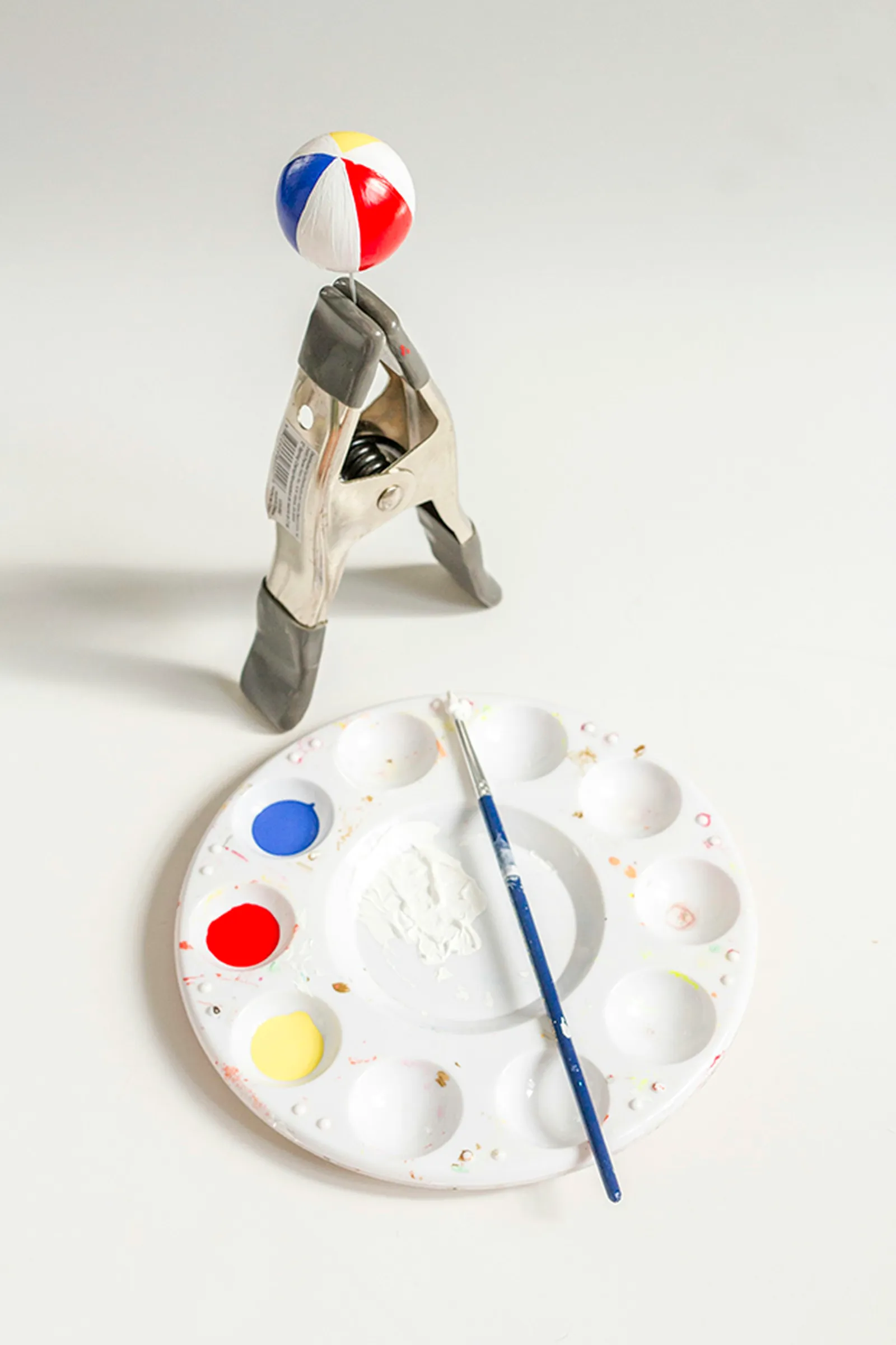 Paint a ping pong ball in primary colors to mimic a real beach ball.