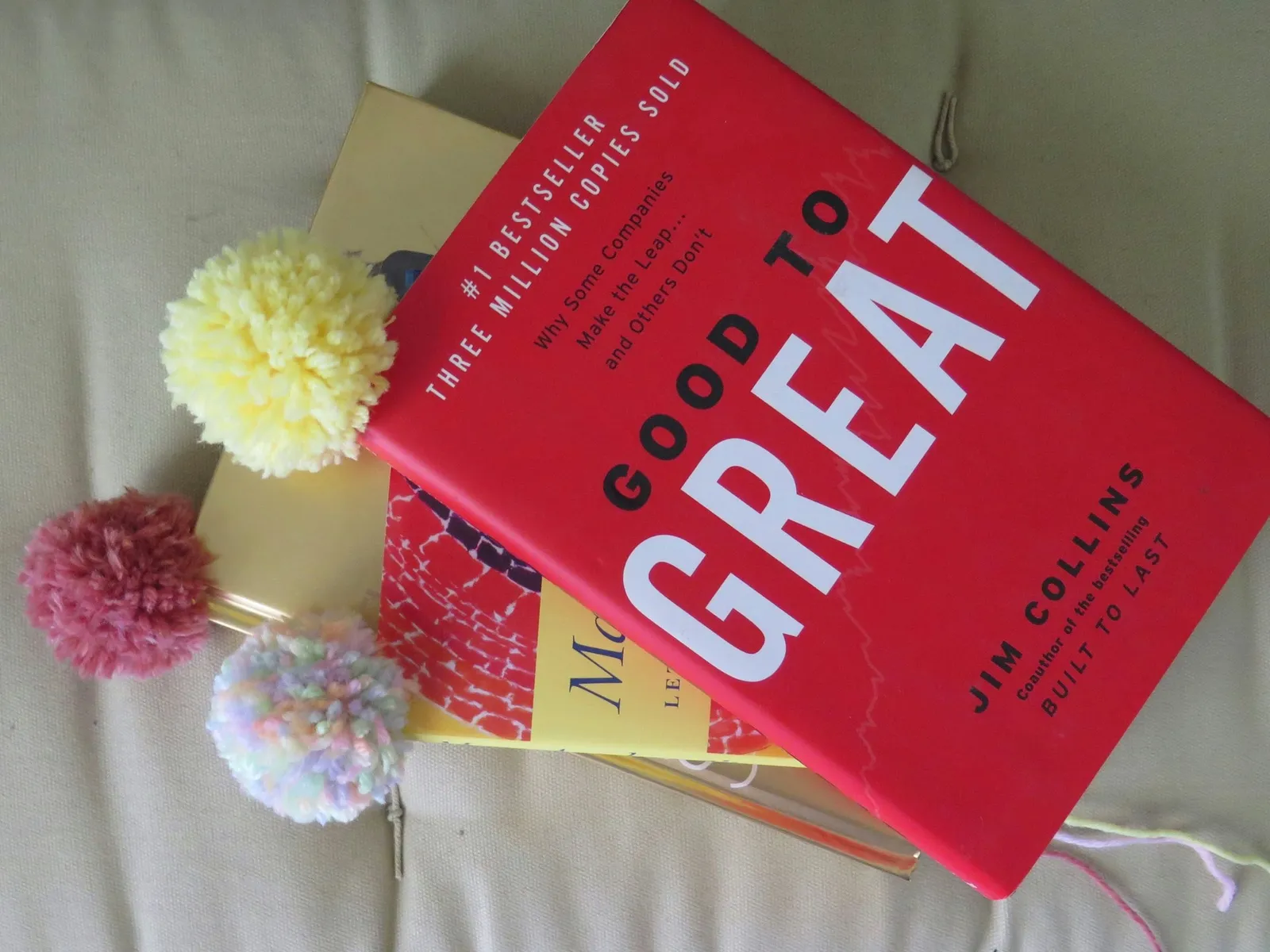 Yarn pompom bookmarks in books.