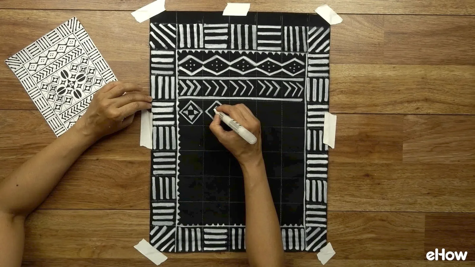 Drawing with paint pen to create DIY mudcloth-inspired wall hanging.
