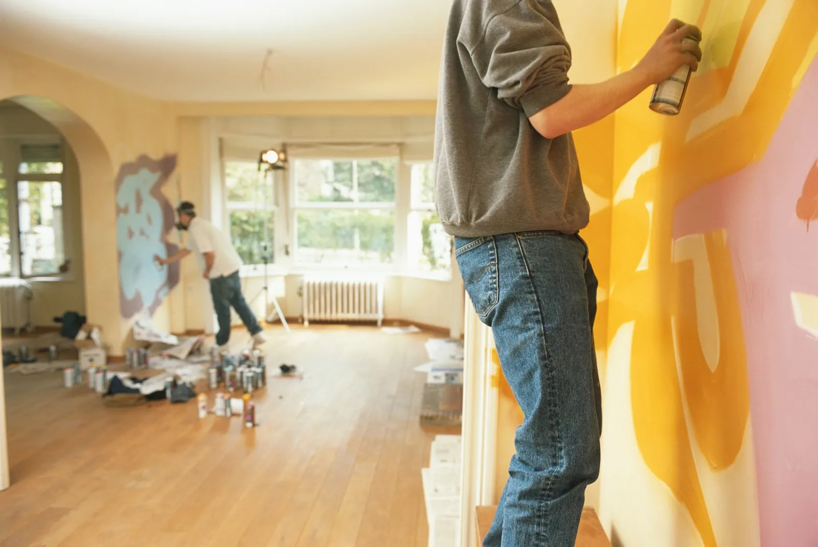 Two men painting wall, side view