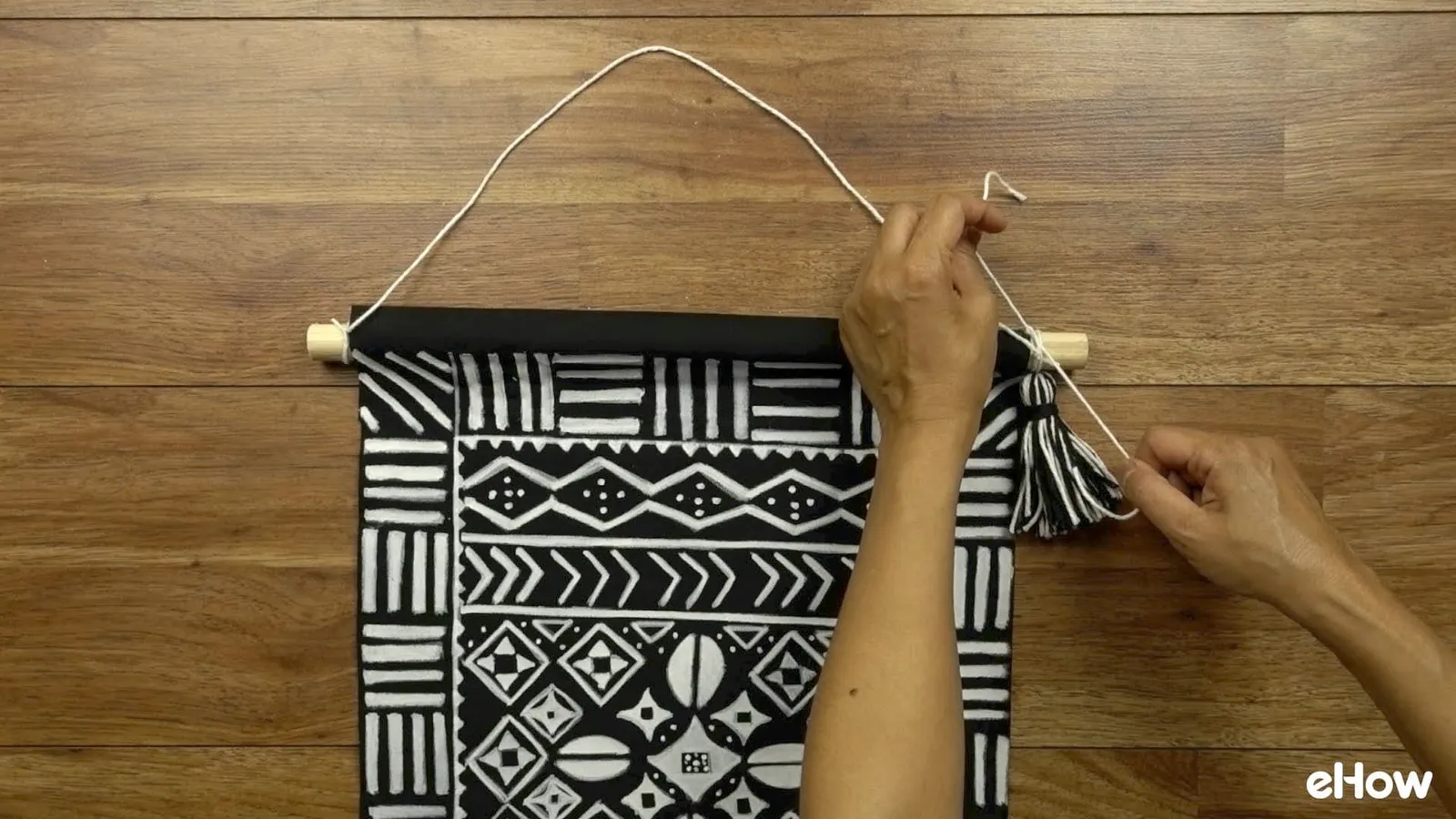 Preparing to hang DIY mudcloth-inspired wall hanging.